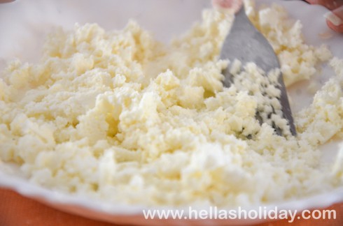 Crumbling feta cheese with a fork