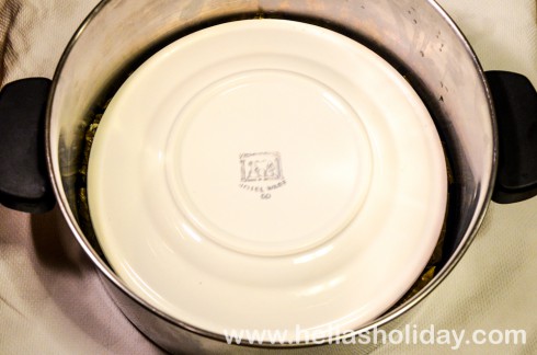 Dolmadakia in the saucepan covered with a heavy plate